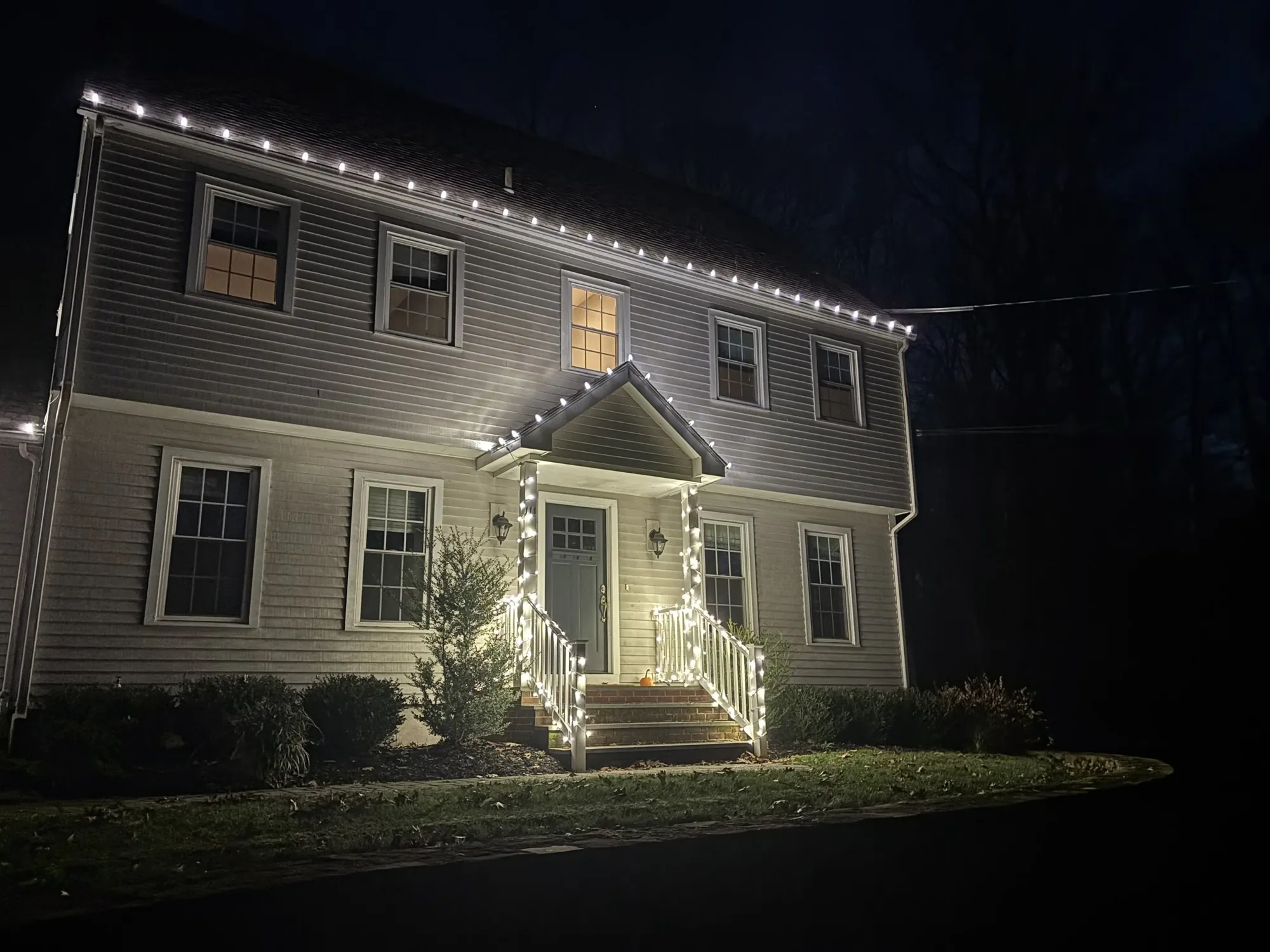 Colonial with a lit roofline, front gable and porch railings